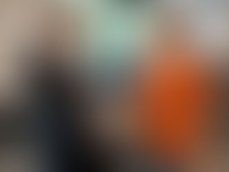 Fotografia realista em ambiente corporativo moderno, mostrando dois profissionais sorrindo enquanto apertam as mãos, um de terno e outro com roupa casual, simbolizando respeito, empatia e relações positivas no trabalho, com equipe ao fundo em um escritório bem iluminado.