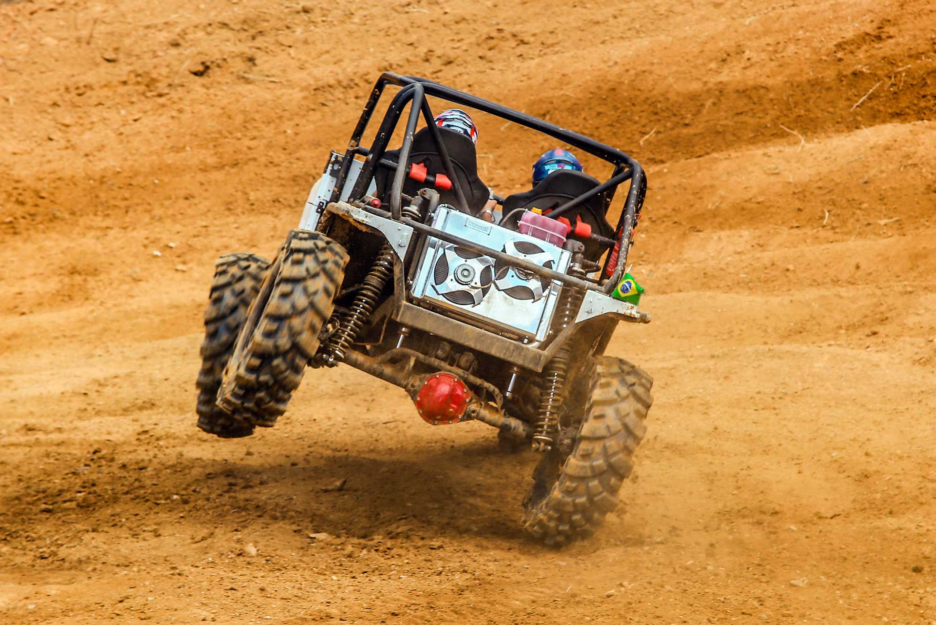 Carro protótipo off-road com piloto e navegador inclinando nas duas rodas ao superar obstáculo na pista do Campeonato Brasileiro Radical 4x4 Genius Tyres em Indaial.