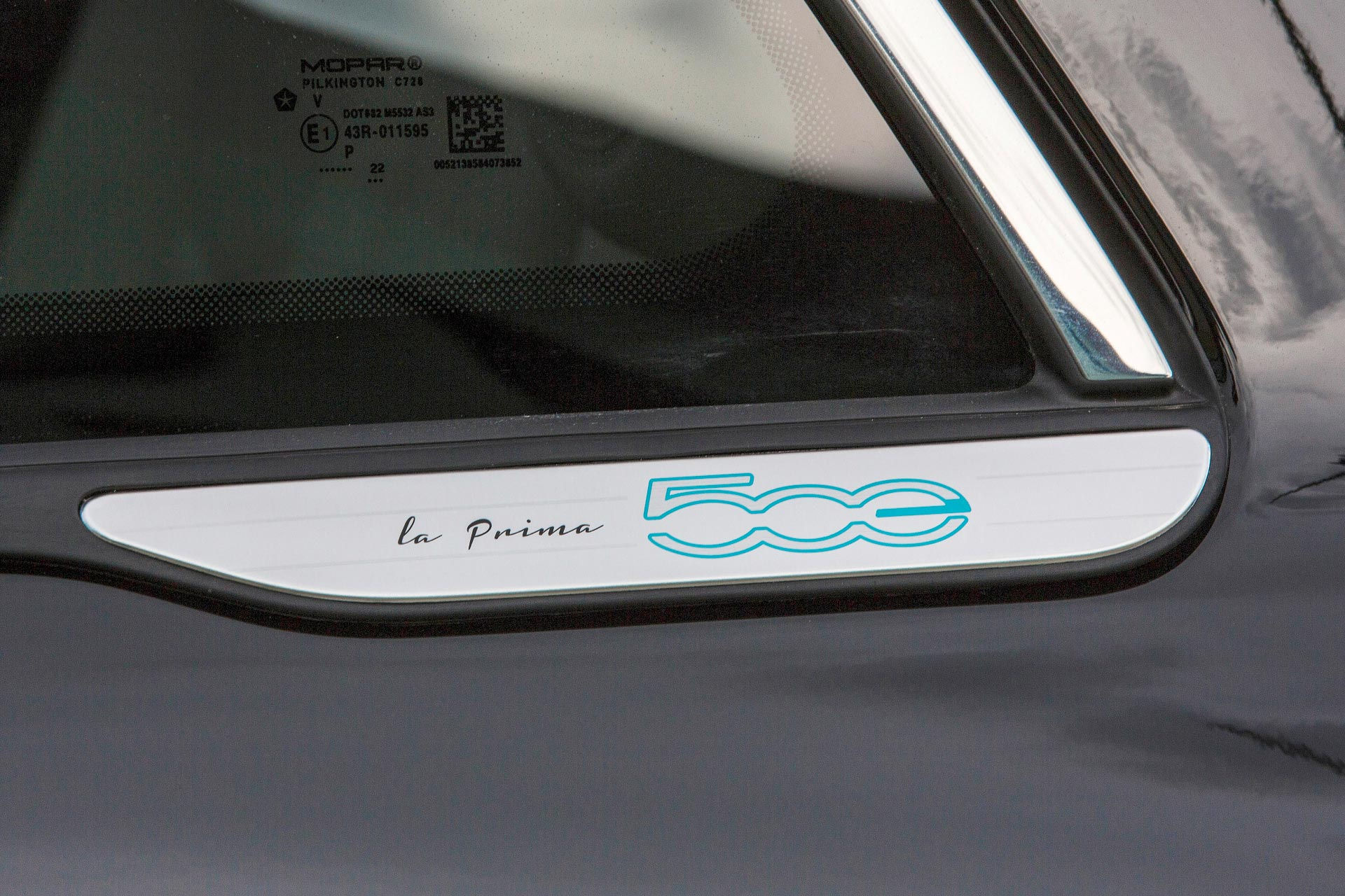 Dettaglio della finitura laterale della FIAT 500 La Prima by Bocelli con firma “la Prima” e logo 500 in blu, elemento esclusivo che identifica l’edizione speciale e rafforza il carattere sofisticato e collezionabile del modello.