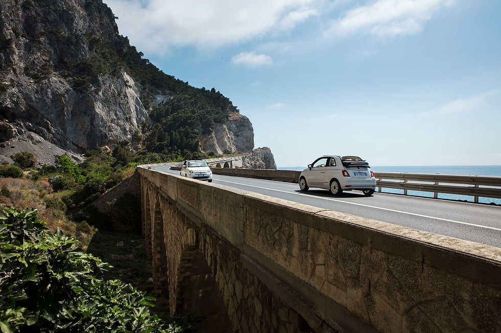 Linda paisagem de estrada no sul da Itália, com FIAT 500 cabriolet passeando, um belo cenário com horizonte formando pelo céu encontrando mar calmo