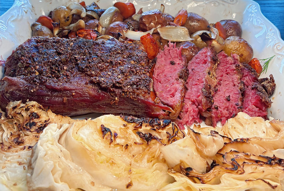 Eye-level view of cooked corned beef brisket on a baking pan with vegetables