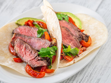 Beef Fajitas served with cilantro and avocado.