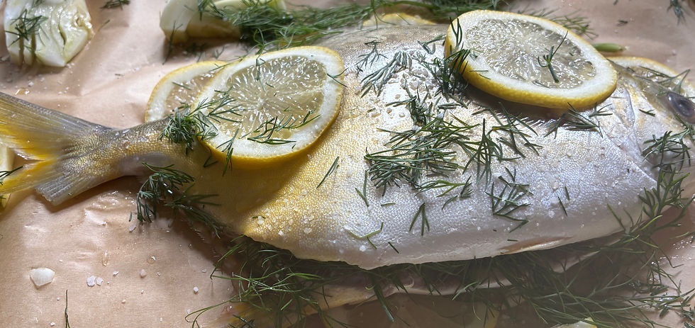 A Pompano sliced open and stuffed with lemon slices and dill.