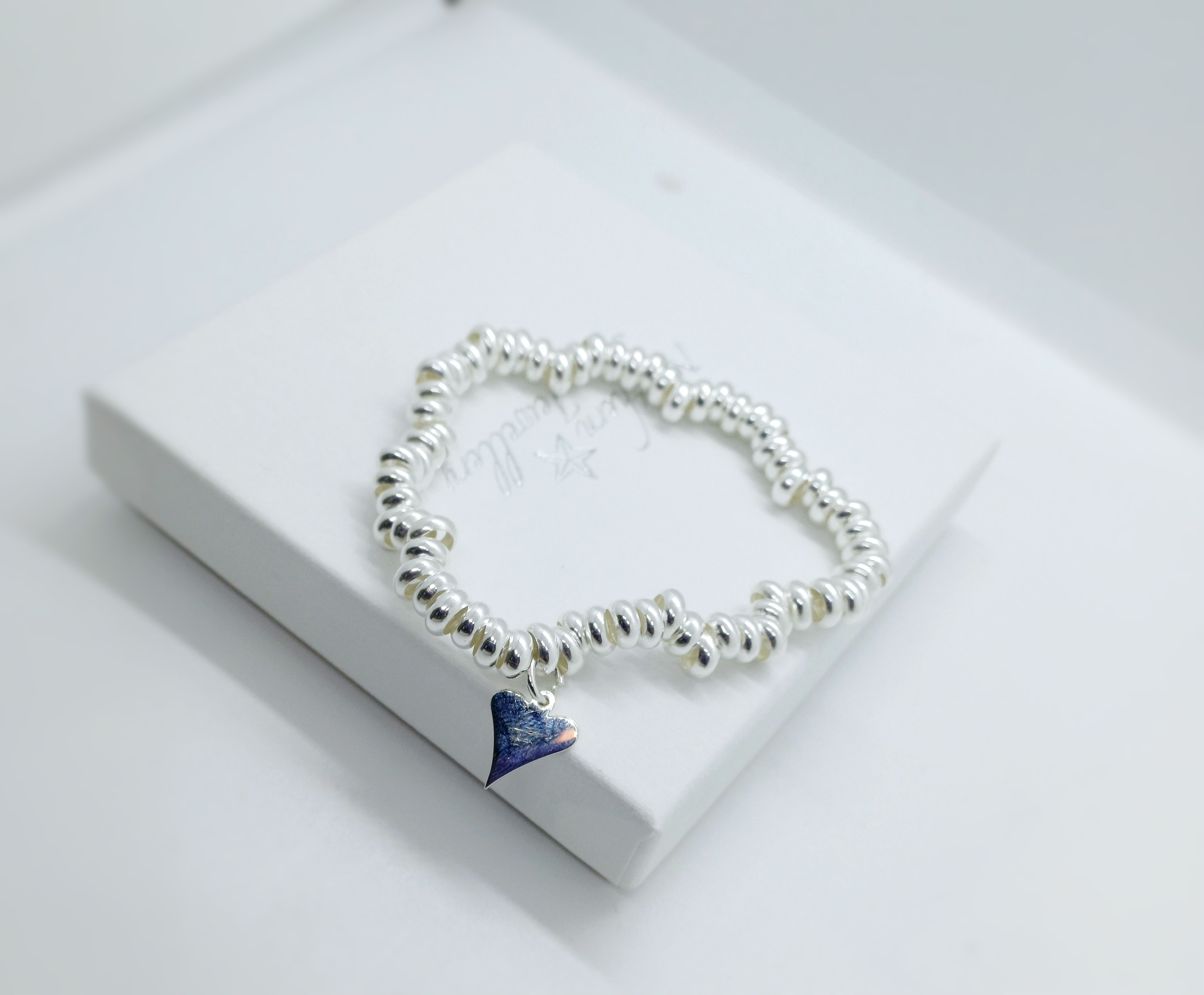 Sterling silver stretch multi ring bracelet with heart charm.