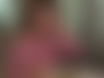 Woman demonstrating how to eat soup at a table with a bowl of soup, cutlery, and a bread basket