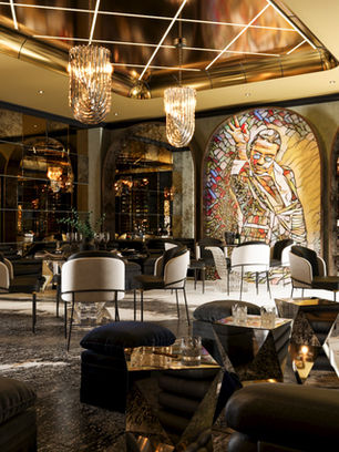 Interior view of a bar with a wooden floor and elegant lighting.