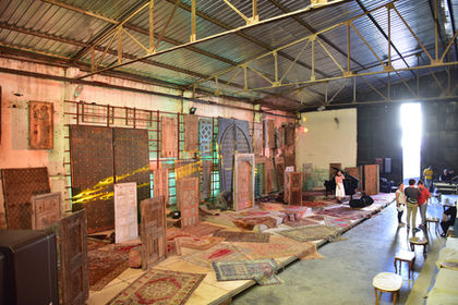 Various wooden doors and carpets displayed inside, natural light filtering in.
