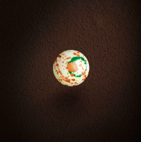 Produktfotografie – Dunkel marmorierte Praline vor tiefblauem Hintergrund, inszeniert wie ein Himmelskörper – Kitchenkiss Studio