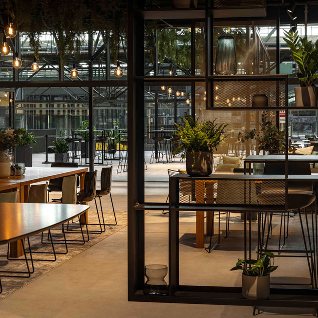 Architekturfotografie für die Gastronomie: Modernes Bistro-Interieur im Industrial Style mit Fokus auf Transparenz.