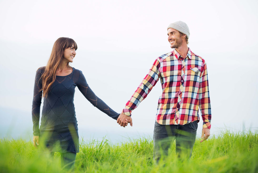 a man and a woman holding hands in a field