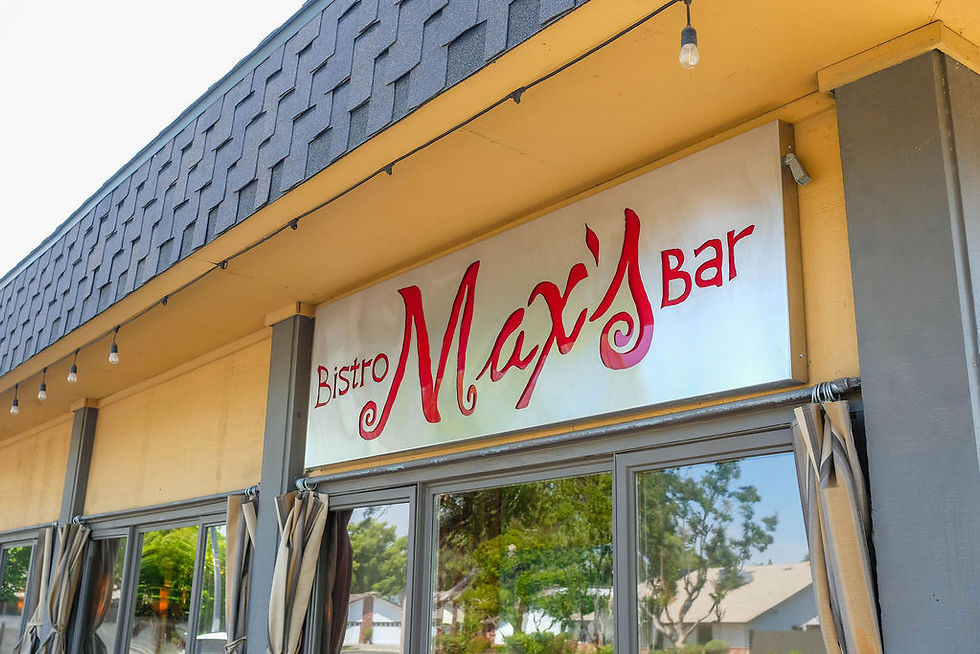 The outside of Max's Bar & Bistro with red sign and yellow walls.