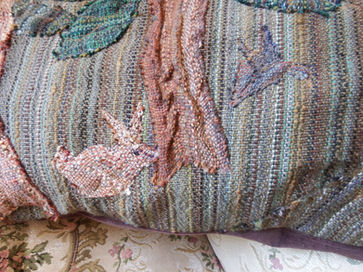 Various strips of colorful, textured fabric hanging or laid out.