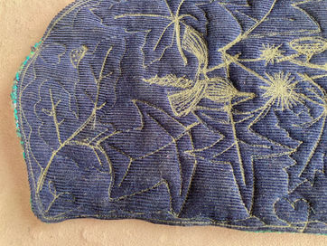 Close-up of textured dark blue fabric with stitched patterns.