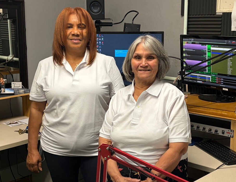 Dos mujeres en cabina de radio con equipos de grabación.