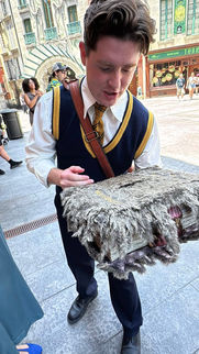 A young man dressed in nice attire is holding the Book of Monsters.