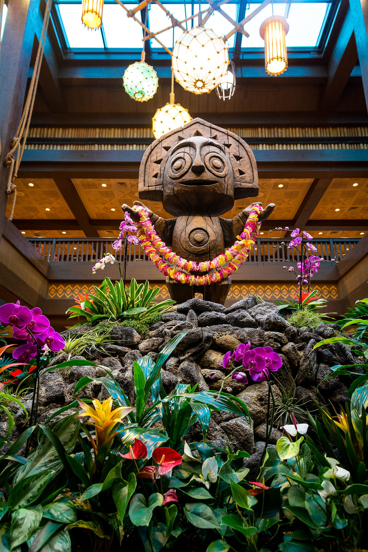 A Hawaiian statue with flowers.