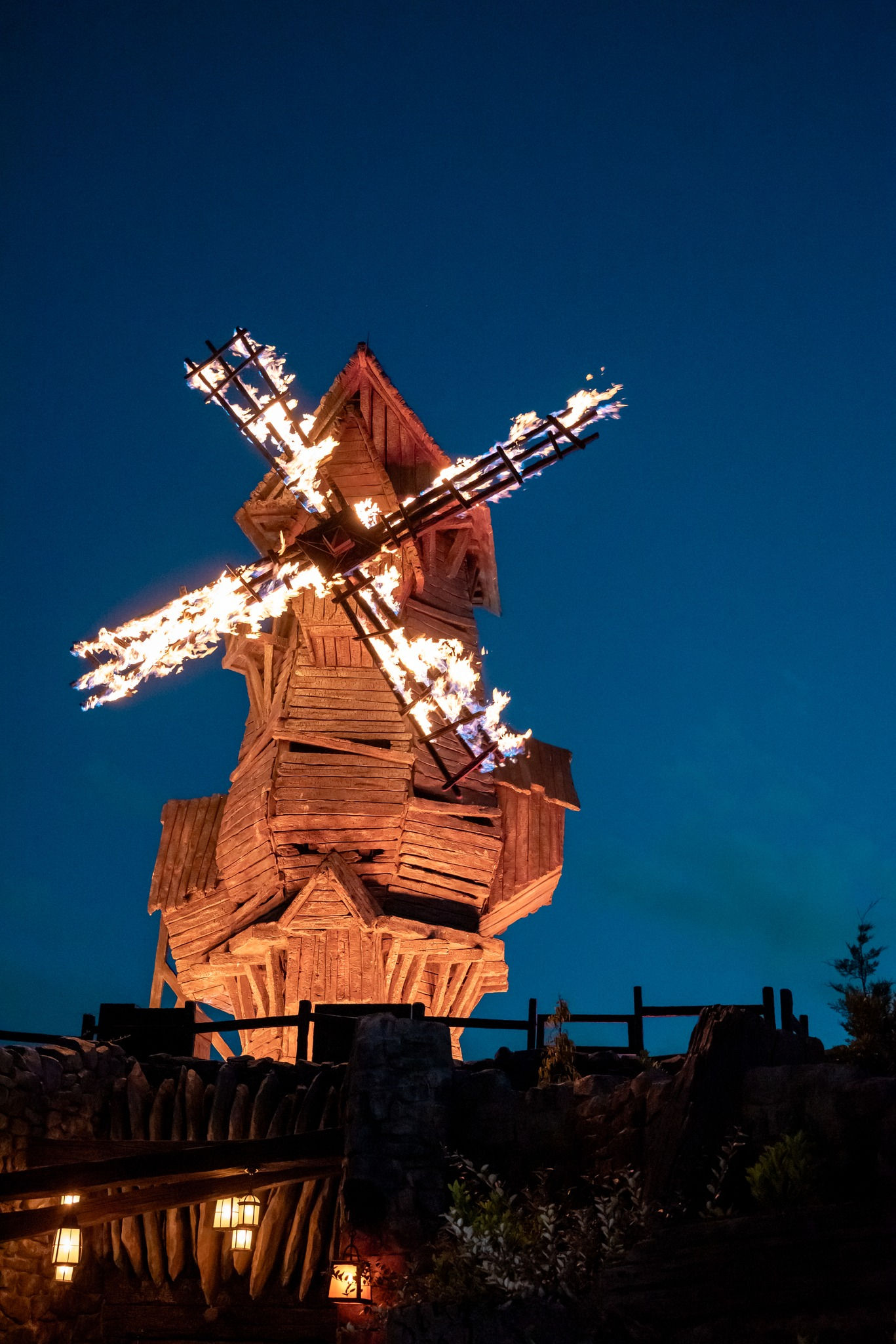 A windmill with fire on its wheel.