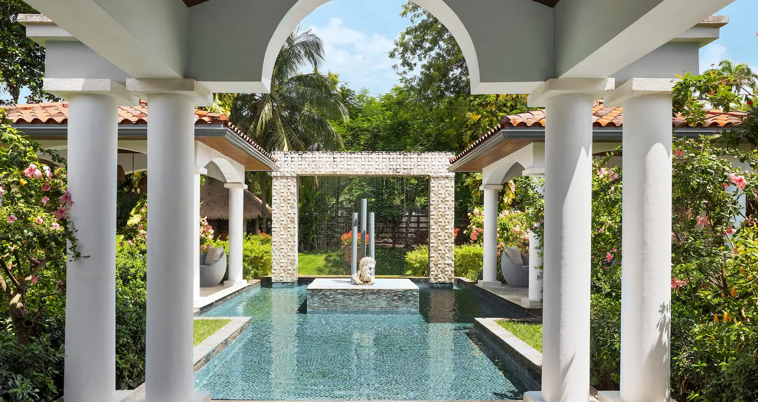 A pool surrounded by tropical plants.