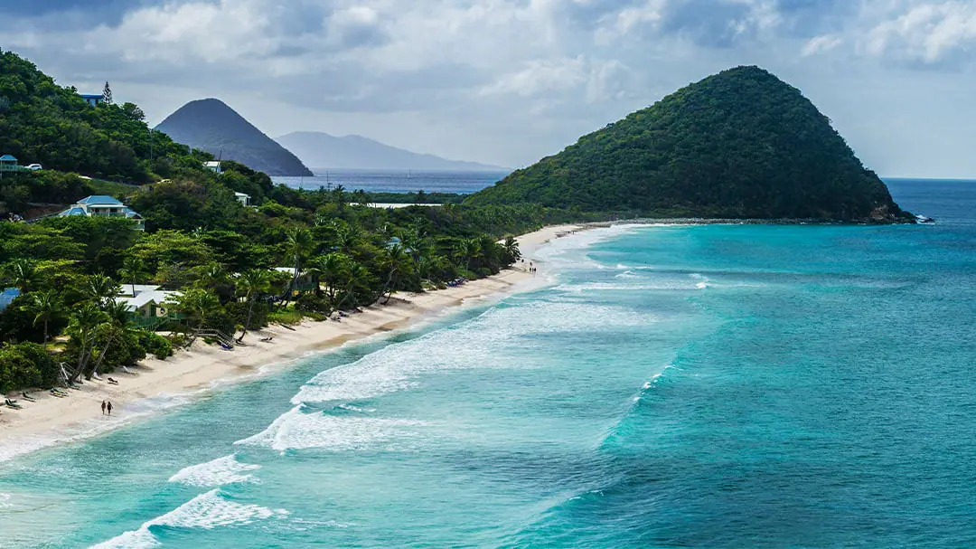 A view of an island surrounded by clear, blue water.