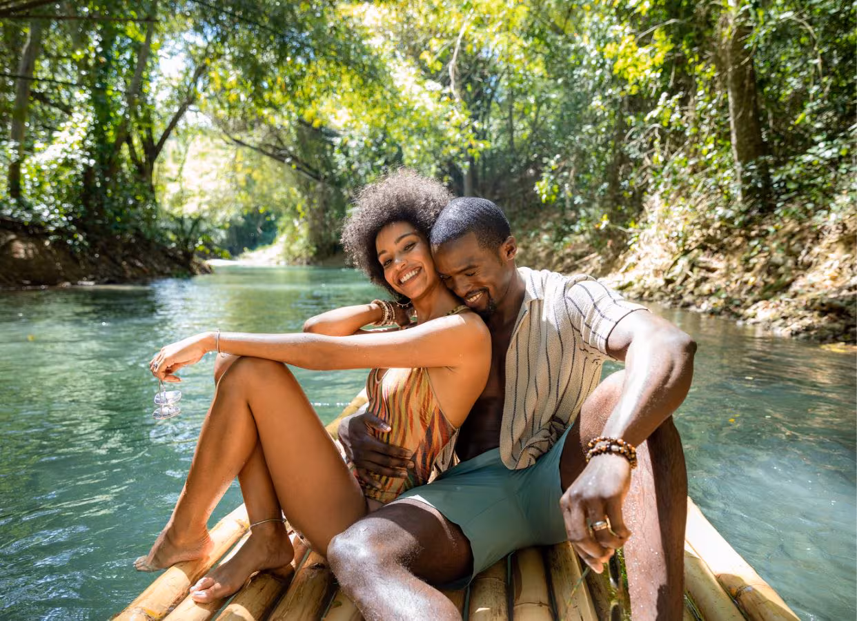 A couple on a bamboo raft going down the river.