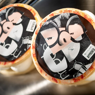 Shortbread Cookie with vanilla frosting, dulce de leche filling, and chocolate décor featuring face of Pixar character, Edna Mode.