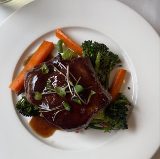 Beef, broccoli, and carrots on a white plate.