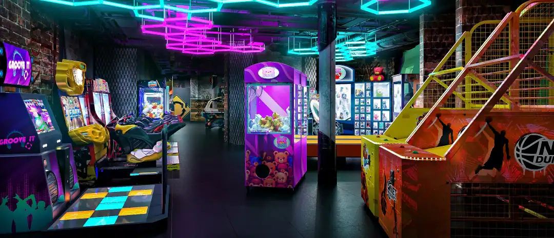 An arcade featuring many games. A claw machine is in the middle. The ceiling is covered in neon lights. 