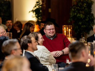 Man smiles while watching Trino's magic show.