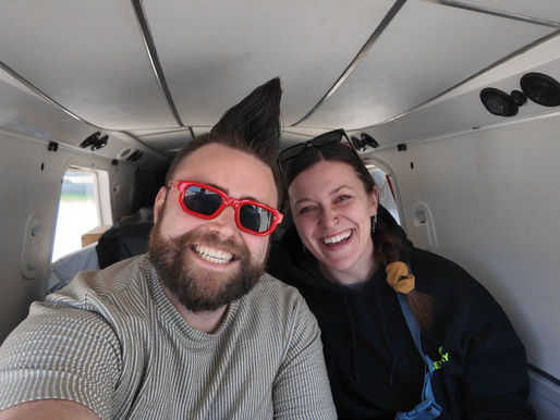 Trino and Ashley on a small prop plane smiling
