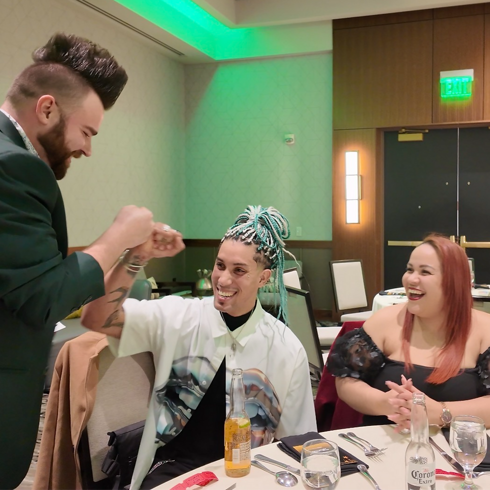Fist bumping after close-up magic during Lansing cocktail hour.