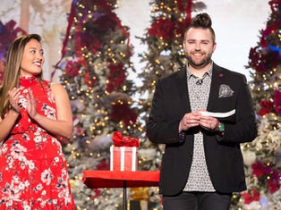 Trino on stage with women. Christmas tree and snow background for the holidays.