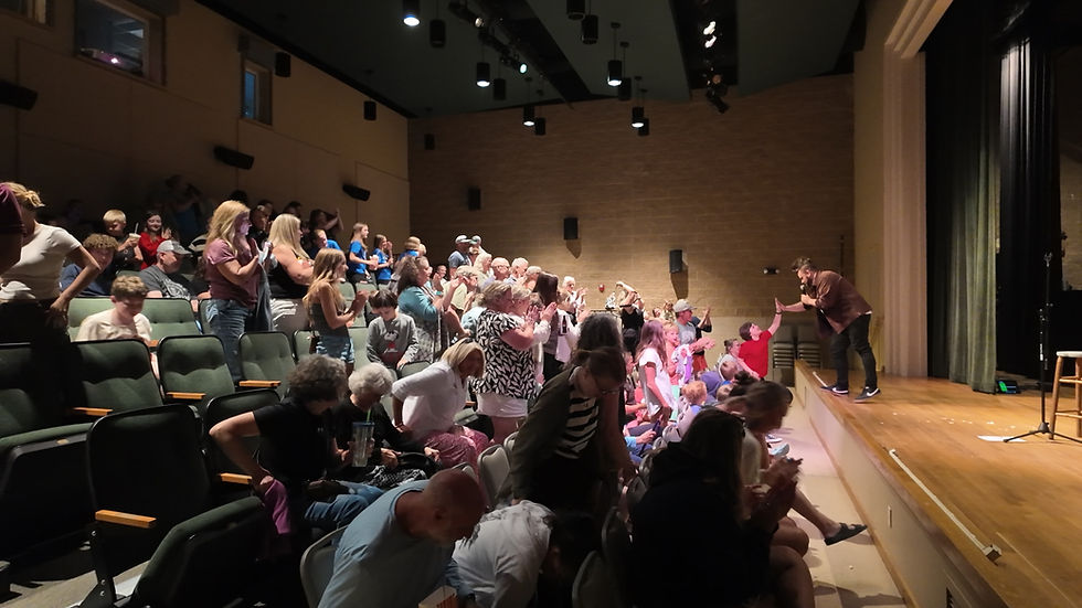 Trino on stage high fiving a child