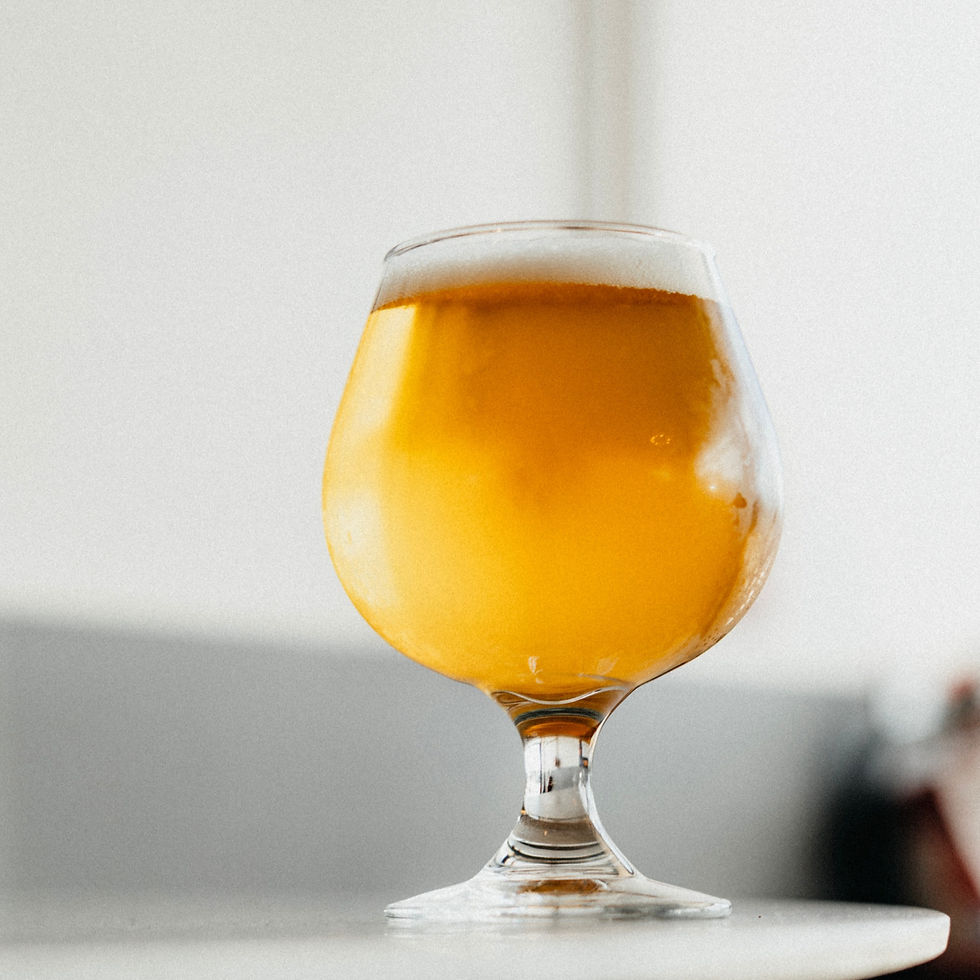 A glass of beer sitting on a white table