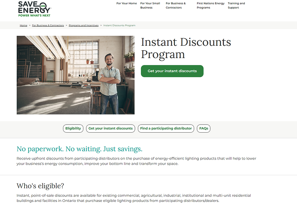Man in workshop with arms crossed, smiling. Text: Instant Discounts Program. Offers energy-efficient lighting savings. Green "Get your instant discounts" button.