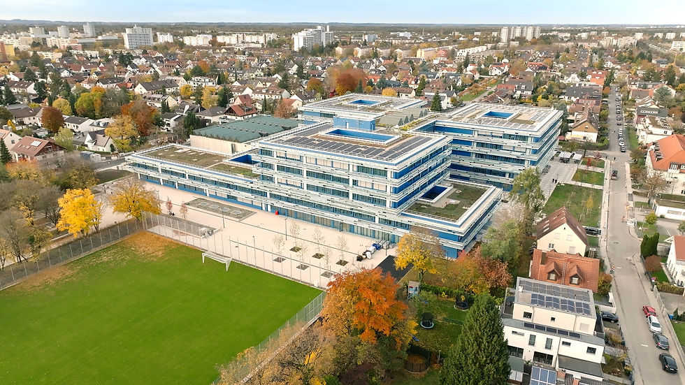 Luftaufnahme der Schule im Endstadium; Fassade sichtbar, Sportplatz und Pausenhöfe entstehen.