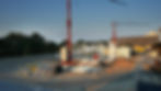 Dokumentation der ersten Stahlträger und Betonelemente; Baukräne bei der Montage.