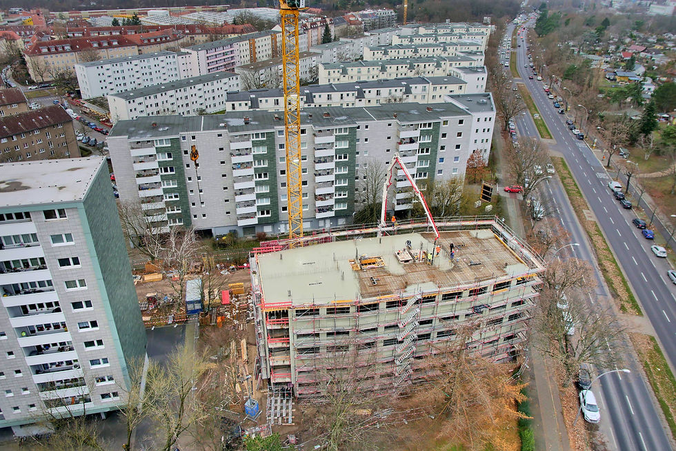 Luftbild: Hochhaus im Skelettbau neben bestehenden Wohnanlagen.