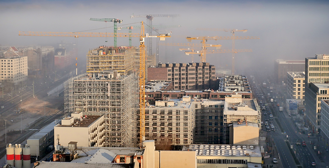 Stadtlandschaft mit Hochhaus-Baustelle und Kränen im Nebel, urbanes Bauprojekt, moderne Architekturentwicklung.