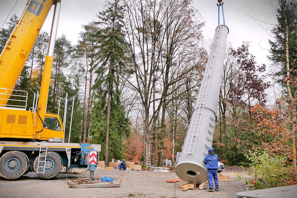 Kran hebt Beton-Mastsegment auf Baustelle in der Lüneburger Heide.