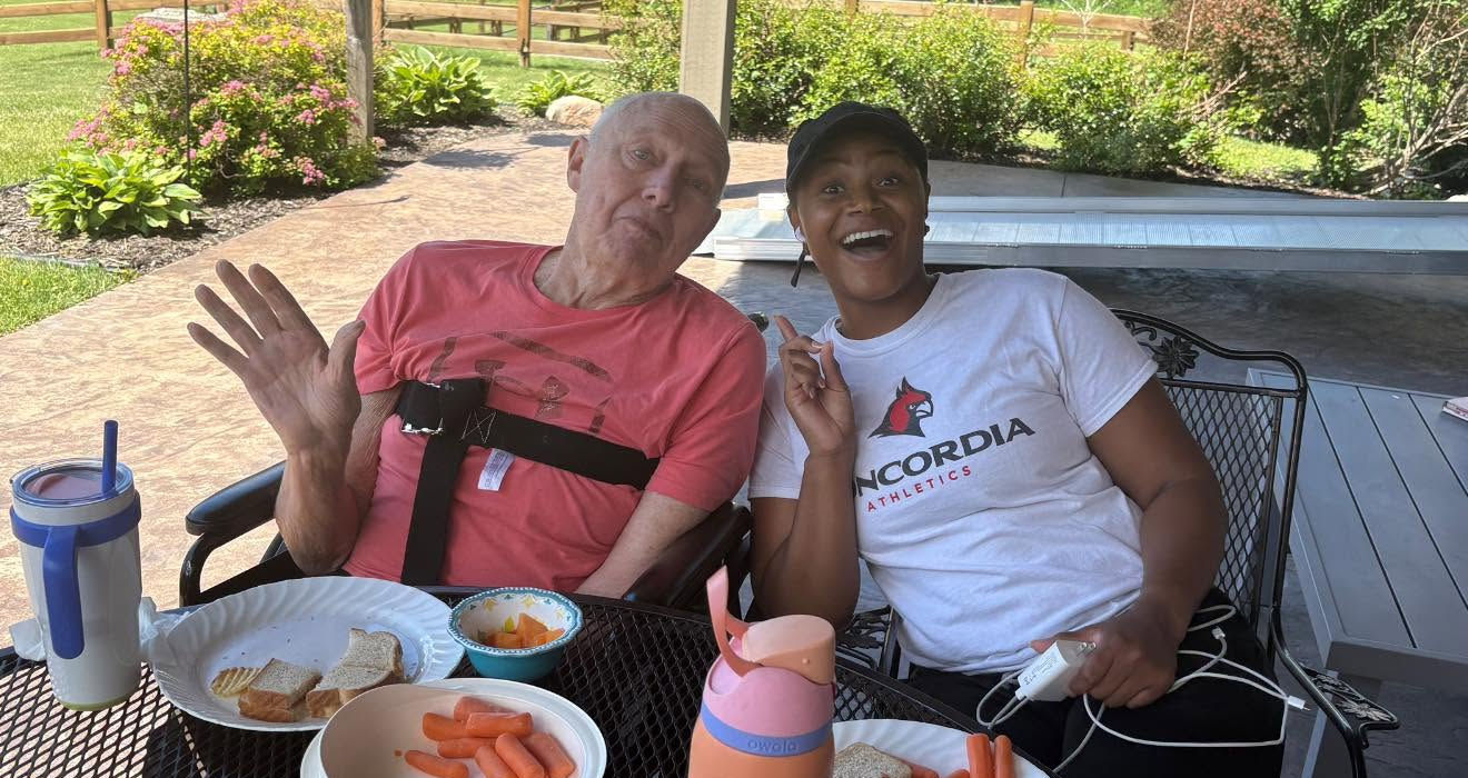 Residents enjoying lunch together on the covered outdoor patio.