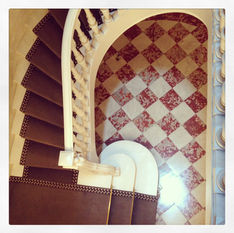 Escalier en colimaçon sur sol en damier rouge et blanc