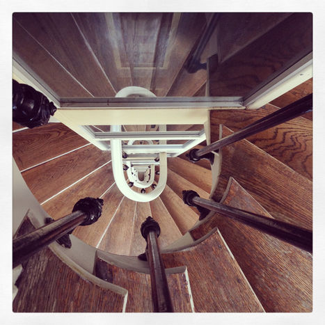Vue en plongée d'un escalier en colimaçon en bois.