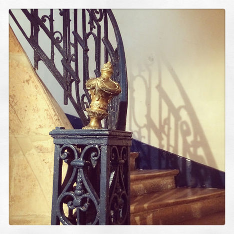 Escalier ancien avec rampe en fer forgé et ornement doré