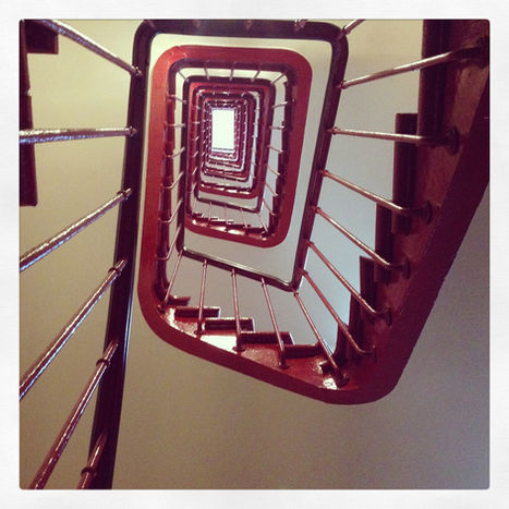 Vue en contre-plongée d'un escalier en colimaçon carré.