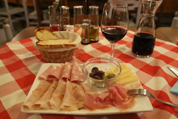 Antipasto-Teller mit Brot, Käse, Oliven und Wein
