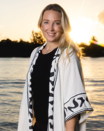 Erin Dahlgren - certified breath guide, standing in front of water at sunset