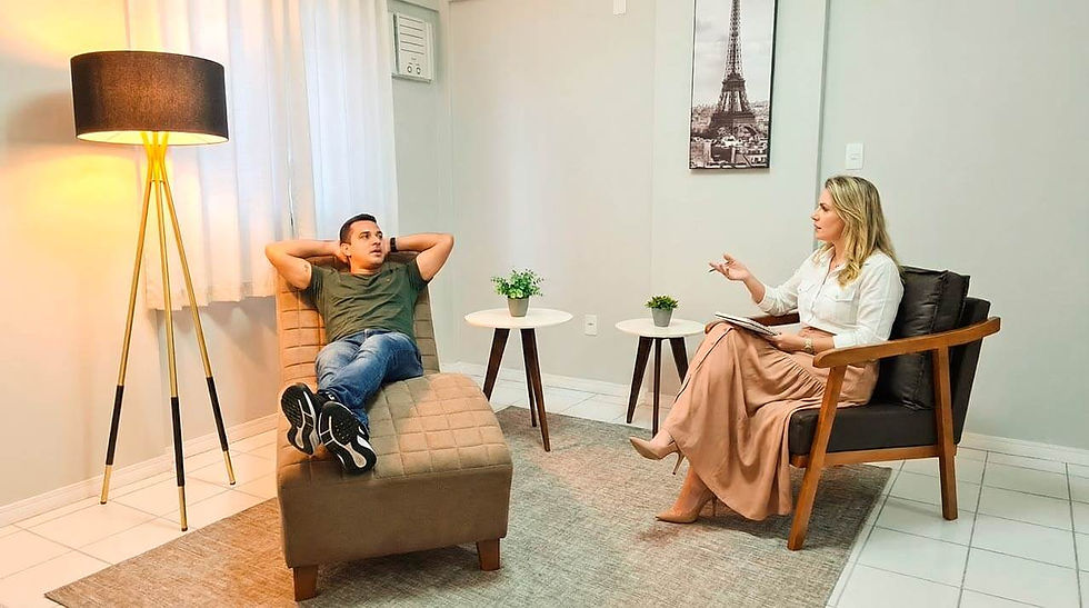 homem deitado em um divã conversando com uma mulher sentada em uma poltrona