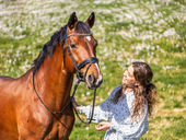 Hest og jente i blomstereng under hestefotografering