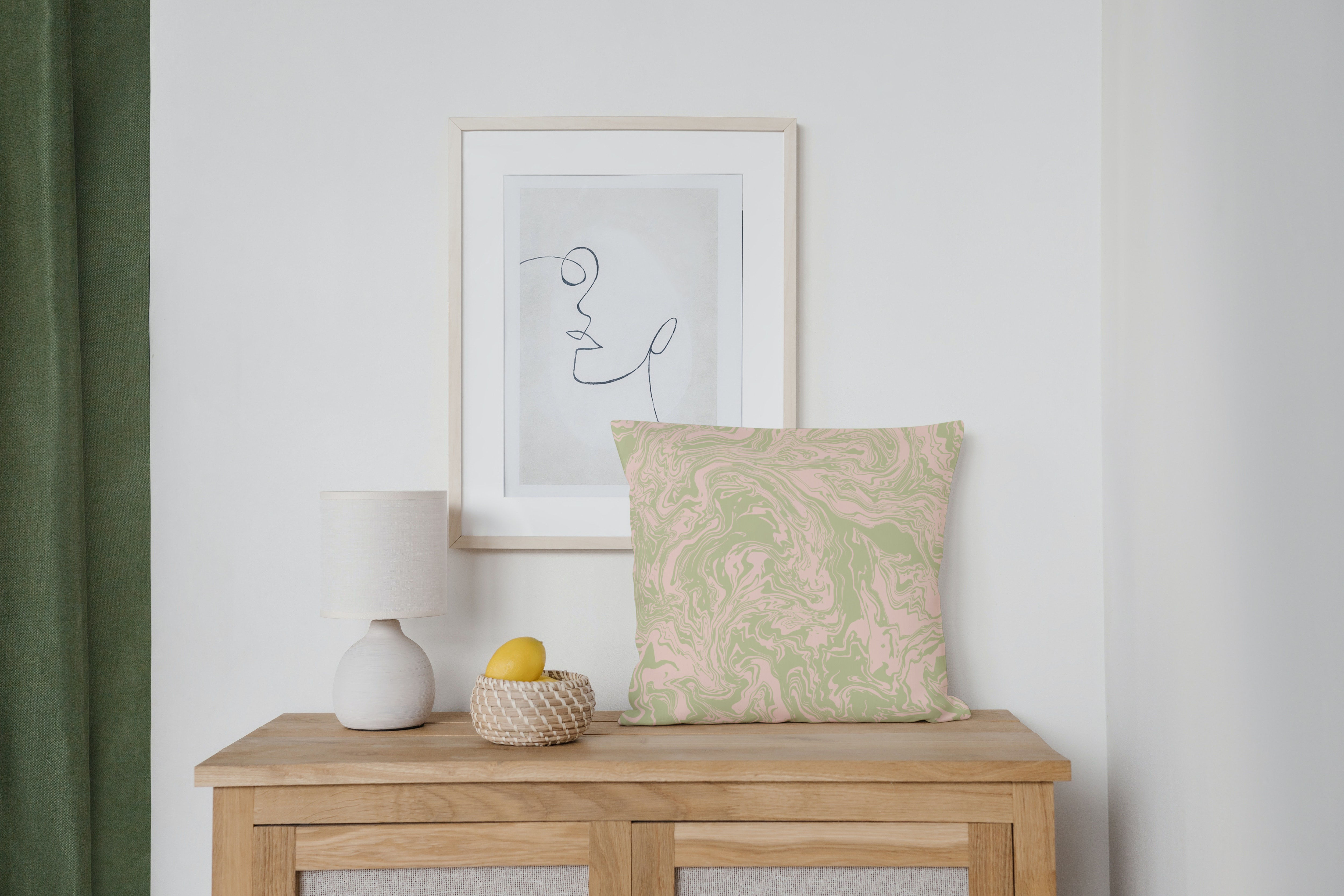 Decorative table with a lamp, art, basket and a swirled cushion.