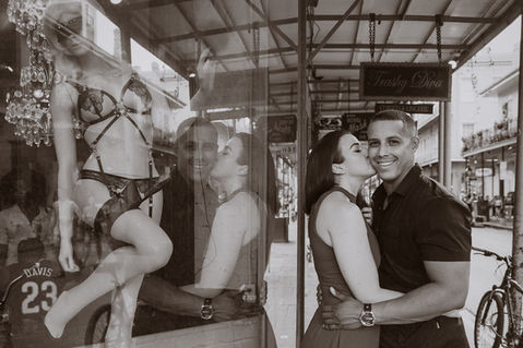 A man smiles at the camera as his soon to be wife kisses him on the cheek next to the Trashy Diva  - Julia Bailey